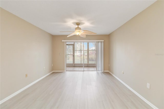 empty room featuring baseboards, a ceiling fan, and light wood-style floors