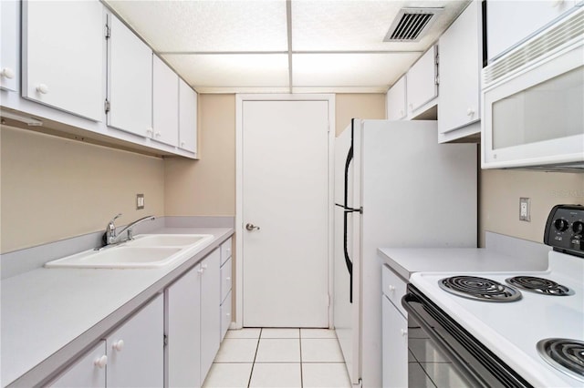 kitchen with electric range oven, white microwave, visible vents, and white cabinets