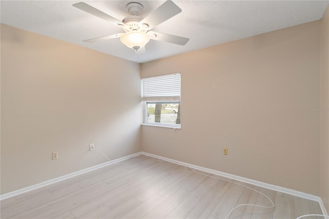 empty room with light wood-style floors, ceiling fan, a textured ceiling, and baseboards