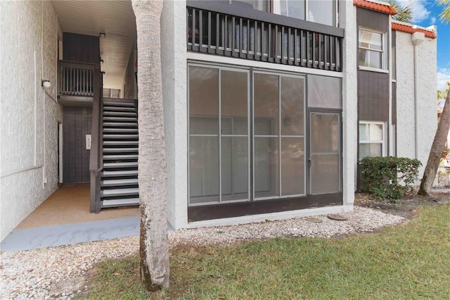 exterior space featuring stairway and stucco siding