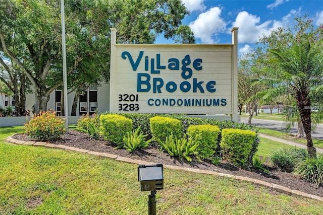 community / neighborhood sign featuring a lawn