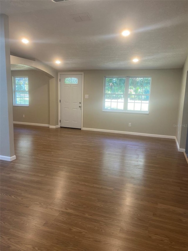 foyer entrance with dark hardwood / wood-style flooring and a textured ceiling