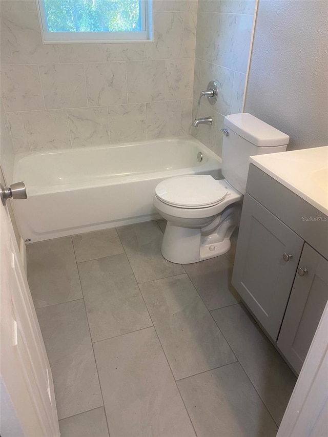 full bathroom featuring tile patterned flooring, vanity, toilet, and tiled shower / bath combo