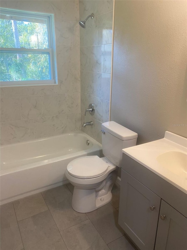 full bathroom featuring tile patterned floors, tiled shower / bath combo, toilet, and vanity