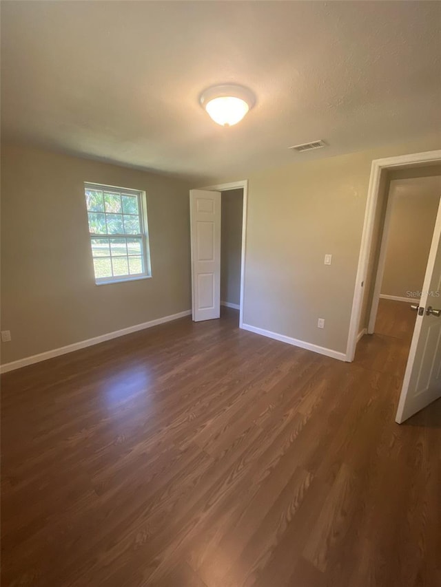 empty room with dark hardwood / wood-style flooring