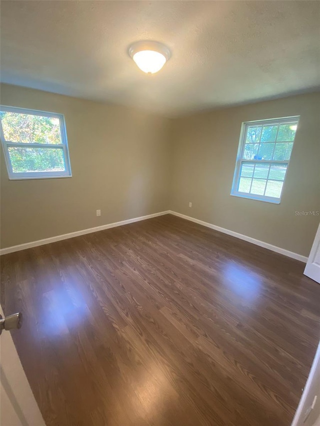 empty room with dark hardwood / wood-style floors