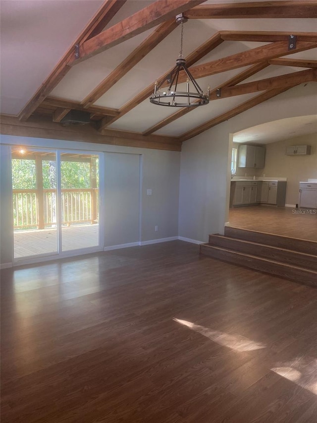 unfurnished living room with lofted ceiling with beams and dark hardwood / wood-style floors