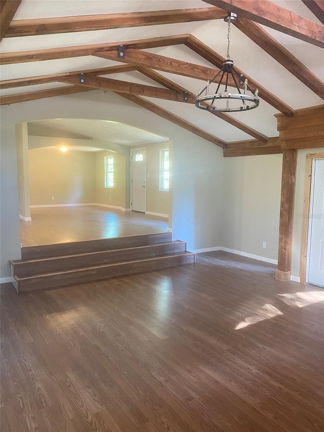 unfurnished living room with vaulted ceiling with beams, dark hardwood / wood-style flooring, and a notable chandelier