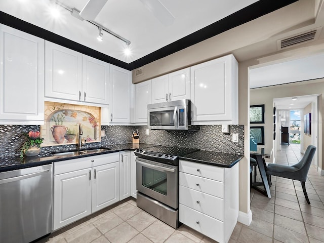 kitchen with white cabinetry, sink, stainless steel appliances, tasteful backsplash, and light tile patterned floors