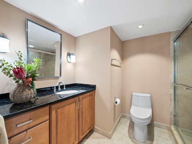 bathroom featuring tile patterned flooring, vanity, toilet, and a shower with shower door