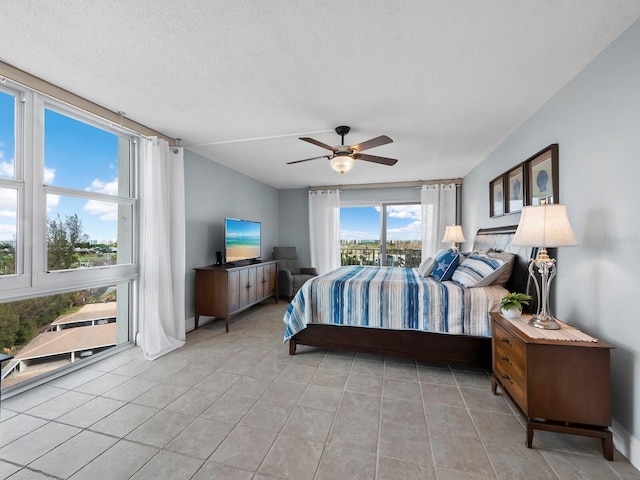 bedroom featuring multiple windows, light tile patterned floors, and ceiling fan