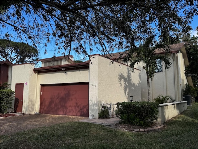 view of home's exterior with a garage, a yard, and central AC unit