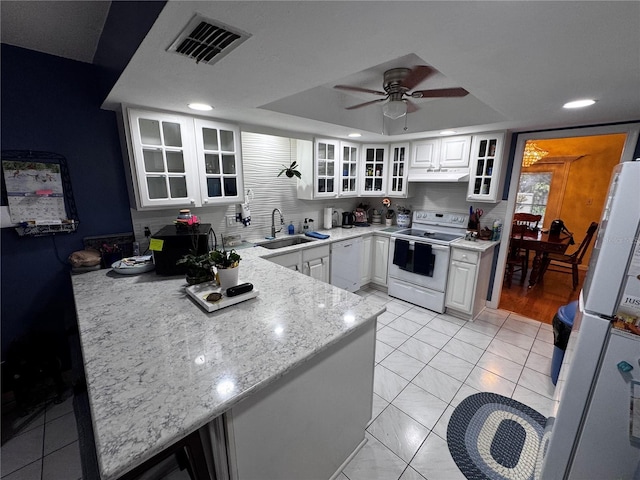 kitchen with white cabinetry, sink, white appliances, and a tray ceiling