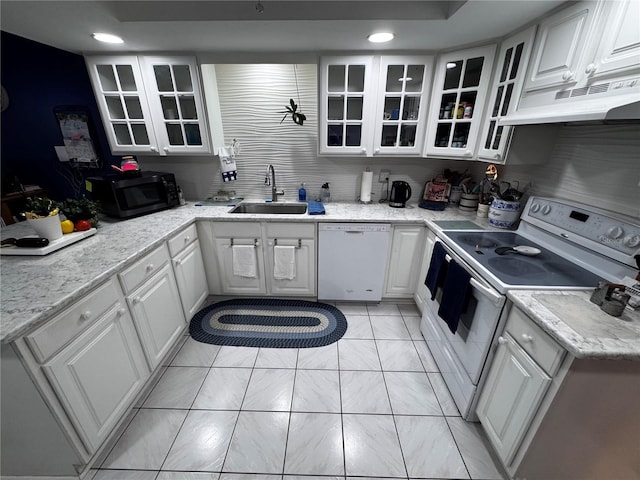 kitchen with white appliances, light stone countertops, sink, and white cabinets