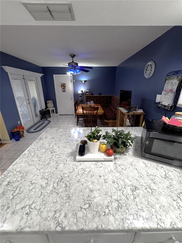 interior space with ceiling fan and light tile patterned floors