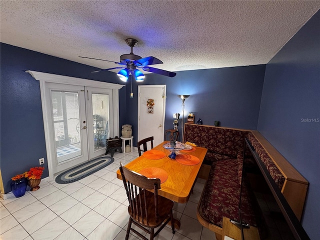 tiled dining area featuring ceiling fan, a textured ceiling, and french doors