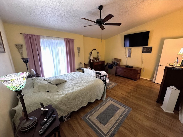 bedroom with lofted ceiling, ceiling fan, dark wood-type flooring, and a textured ceiling