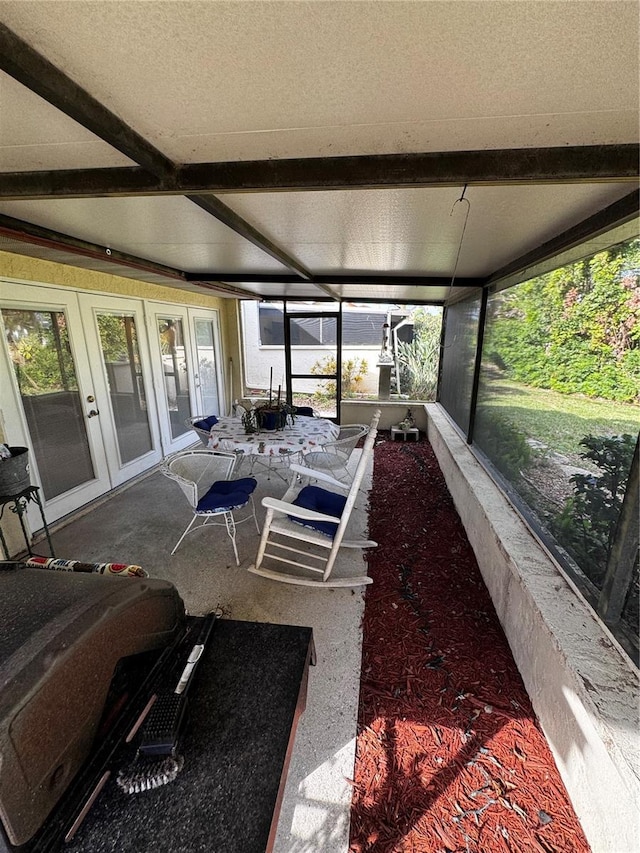 sunroom featuring beam ceiling