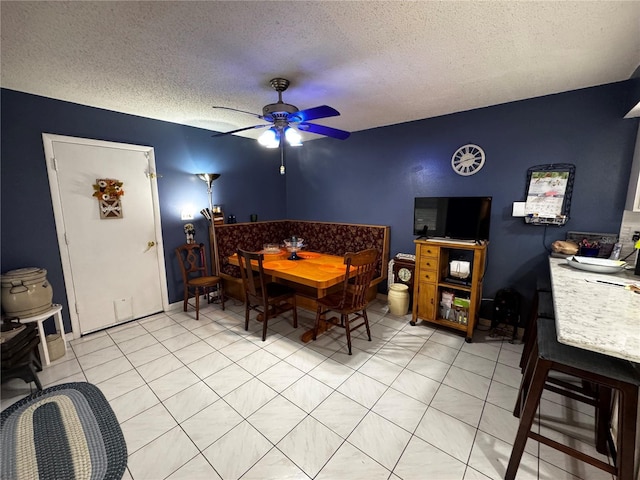 dining room featuring ceiling fan, a textured ceiling, and light tile patterned floors