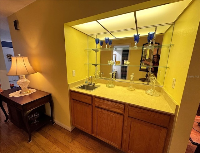 bar with hardwood / wood-style flooring and sink