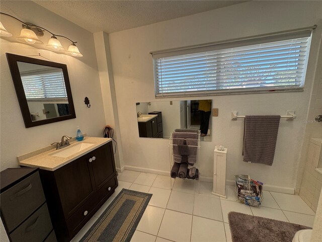 bathroom with tile patterned flooring, vanity, and a textured ceiling