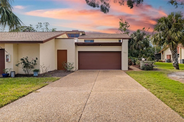 view of front of home with a yard and a garage