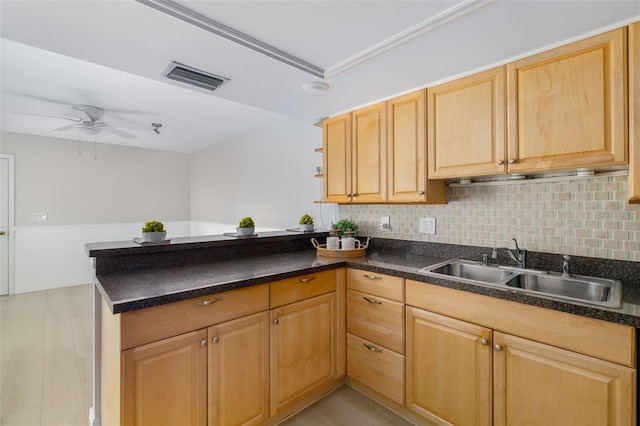 kitchen with kitchen peninsula, light hardwood / wood-style flooring, ceiling fan, and sink