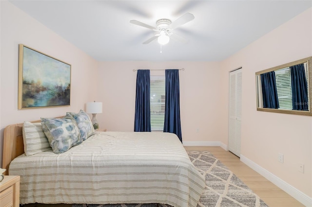 bedroom with ceiling fan, a closet, and light hardwood / wood-style flooring