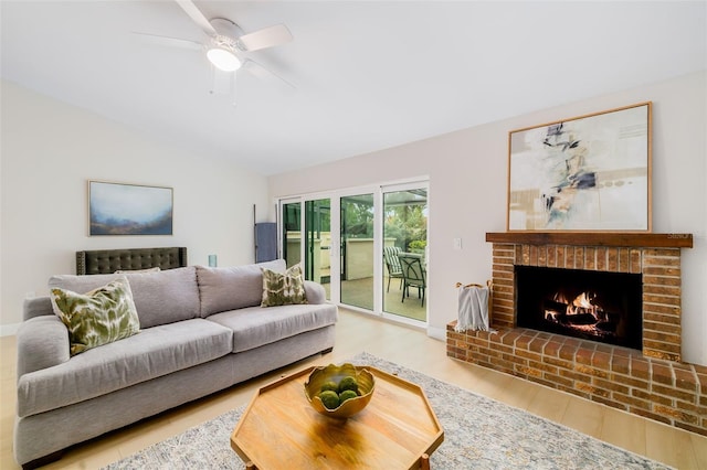 living room with ceiling fan, a fireplace, and hardwood / wood-style flooring