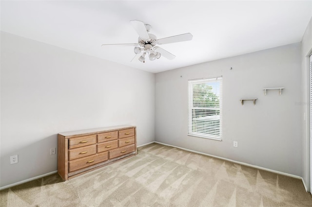 unfurnished bedroom featuring light colored carpet and ceiling fan