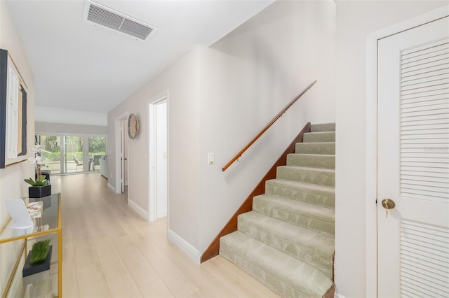 staircase with hardwood / wood-style floors