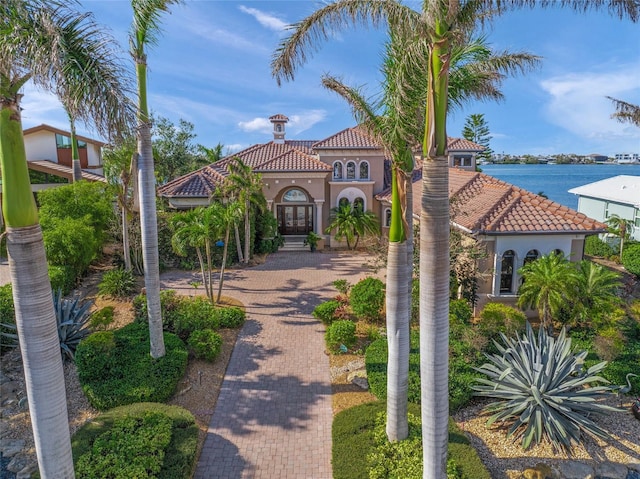 mediterranean / spanish-style home featuring french doors and a water view