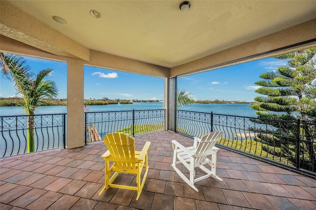 view of patio / terrace with a water view and a balcony