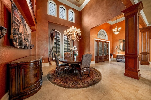 dining space with ornate columns, crown molding, a high ceiling, and french doors