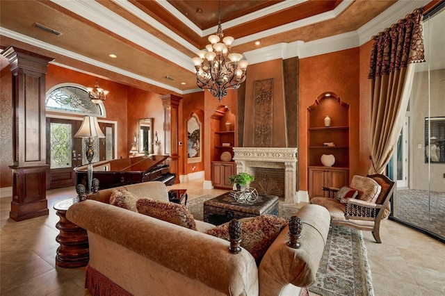 living room featuring ornate columns, ornamental molding, built in shelves, a raised ceiling, and an inviting chandelier