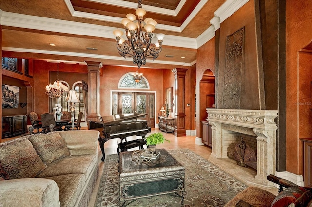 interior space featuring a chandelier, crown molding, a tray ceiling, and decorative columns