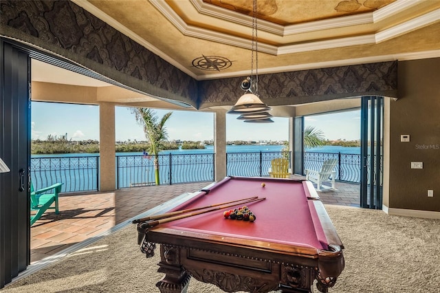 game room with a healthy amount of sunlight, a raised ceiling, and a water view