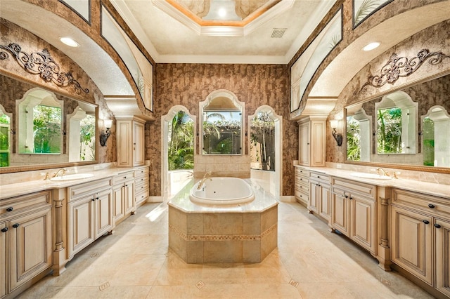 bathroom with vanity, crown molding, tiled tub, and decorative columns