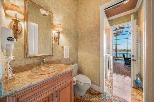 bathroom featuring vanity, a water view, toilet, and ornamental molding