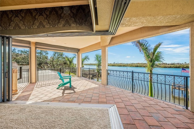 view of patio with a balcony and a water view