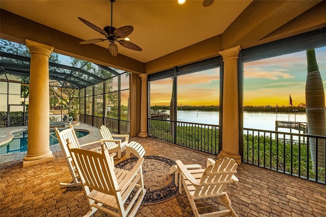 sunroom / solarium featuring a water view, ceiling fan, and a swimming pool