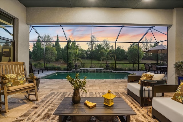 pool at dusk with a lanai and a patio area