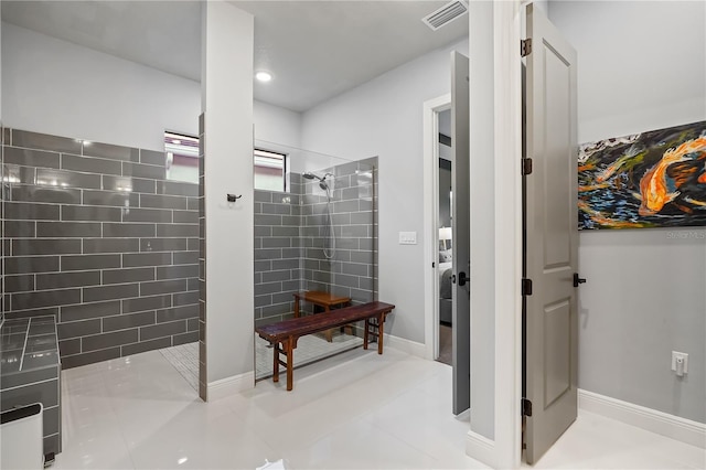 bathroom featuring tiled shower and tile patterned floors