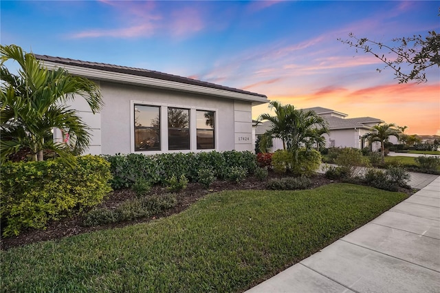 property exterior at dusk with a yard