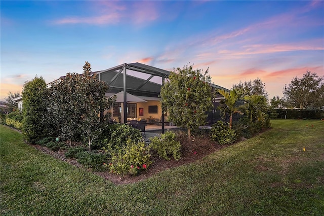 yard at dusk with a lanai and a patio area