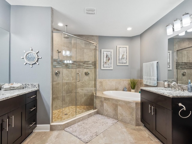 bathroom with tile patterned floors, vanity, and shower with separate bathtub