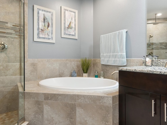 bathroom featuring shower with separate bathtub and vanity