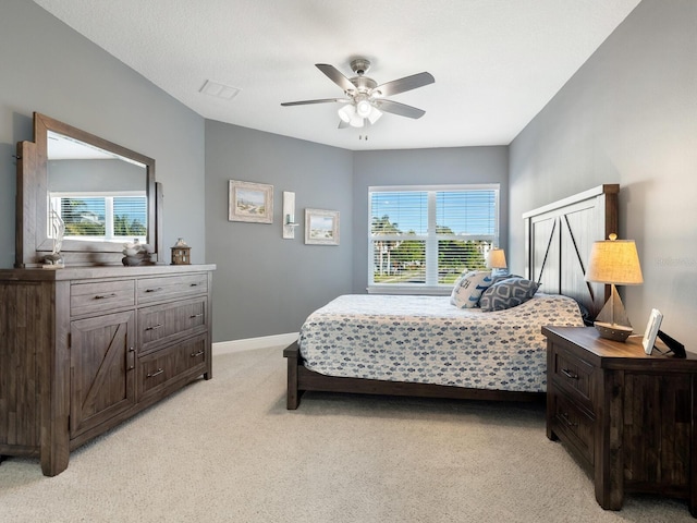 carpeted bedroom featuring multiple windows and ceiling fan