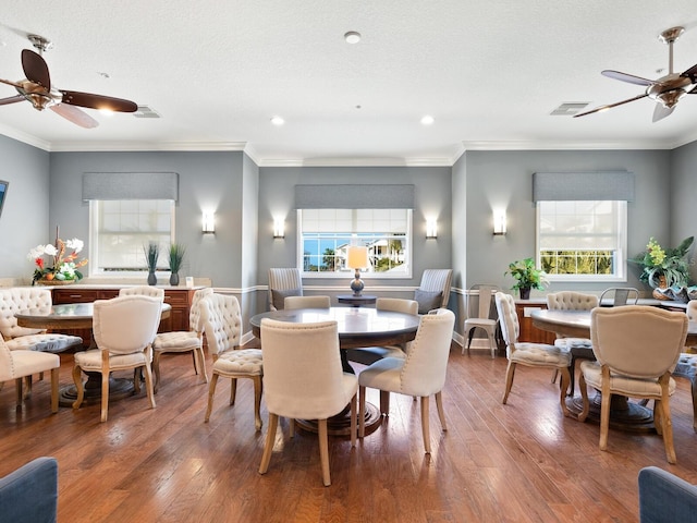 dining area with crown molding, ceiling fan, a textured ceiling, and hardwood / wood-style flooring