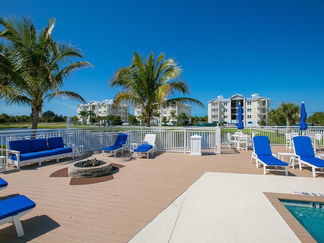 view of swimming pool featuring an outdoor living space with a fire pit